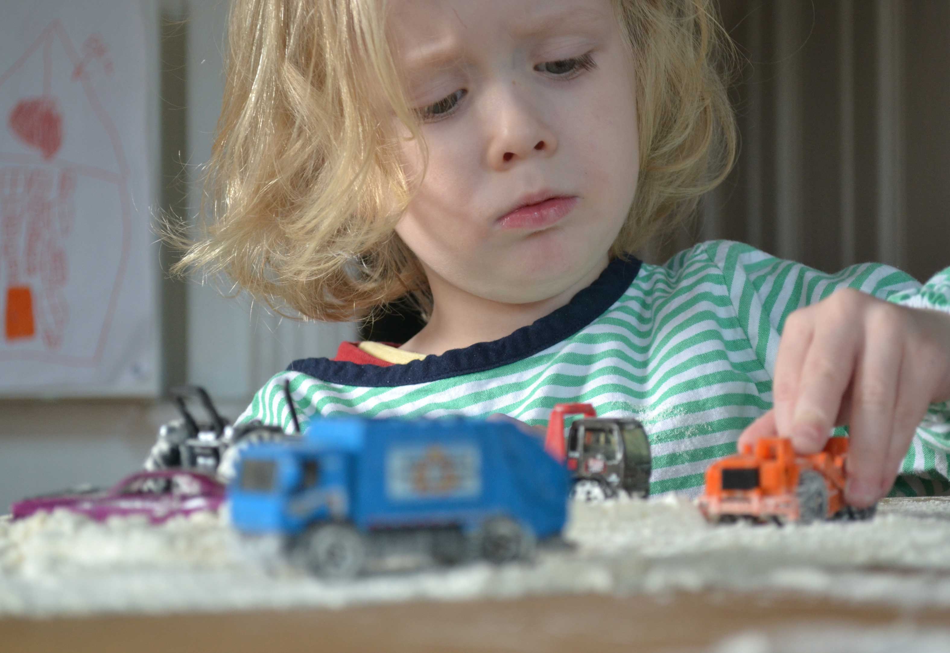 Child playing with toy trucks