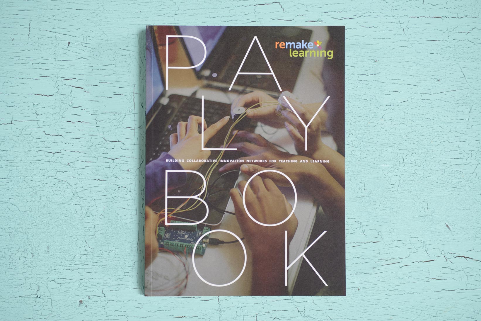 The cover of the Remake Learning Playbook with an image of kids working with circuitry